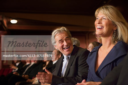 Couple laughing and clapping in theater