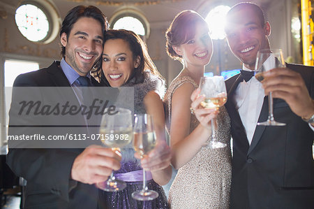 Portrait of well dressed couples toasting champagne and wine glasses