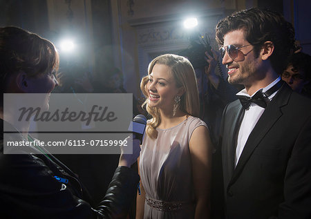 Well dressed celebrity couple being interviewed at red carpet event Well dressed celebrity couple being interviewed at red carpet event
