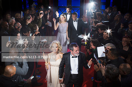 Well dressed celebrities waving to paparazzi on red carpet Well dressed celebrities waving to paparazzi on red carpet