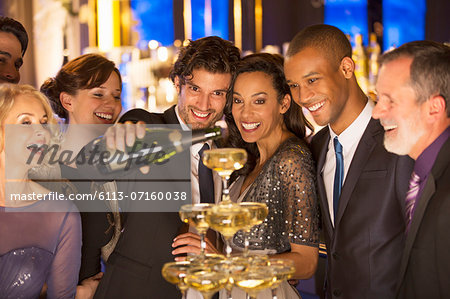 Well dressed man pouring champagne pyramid