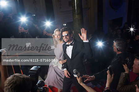 Well dressed celebrity couple waving to paparazzi on red carpet Well dressed celebrity couple waving to paparazzi on red carpet