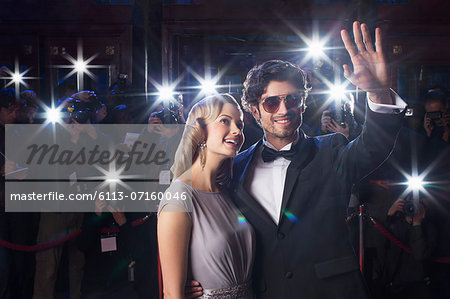 Well dressed celebrity couple waving to paparazzi at red carpet event Well dressed celebrity couple waving to paparazzi at red carpet event