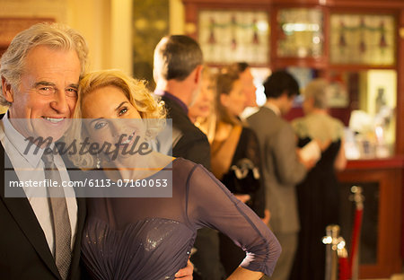 Close up of well dressed couple smiling in theater lobby