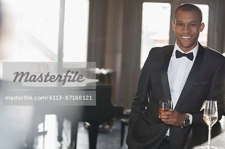 Portrait of well dressed man drinking cocktail in lounge Portrait of well dressed man drinking cocktail in lounge