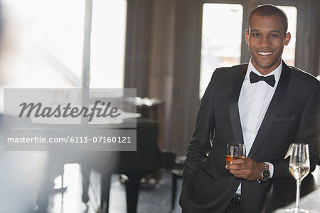 Portrait of well dressed man drinking cocktail in lounge