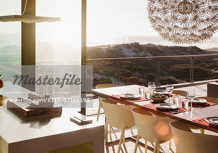 Modern dining room overlooking ocean at sunset