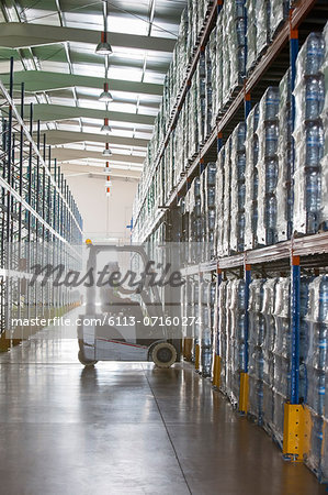 Worker operating forklift in warehouse