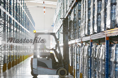 Worker operating forklift in warehouse Worker operating forklift in warehouse