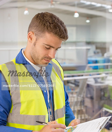 Worker with clipboard in factory