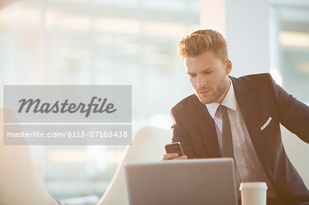 Businessman using cell phone in office Businessman using cell phone in office