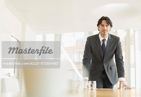 Businessman standing at conference table