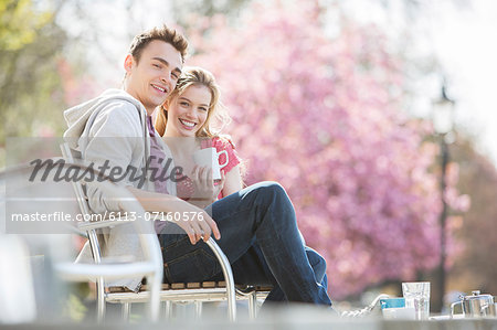 Couple having coffee on park bench