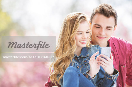Couple using cell phone outdoors