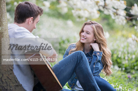 Man playing guitar for girlfriend outdoors