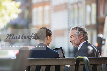 Business people talking on urban bench