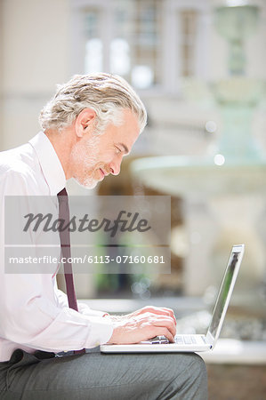 Businessman using laptop outdoors