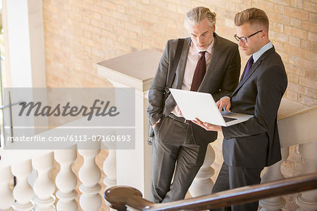 Businessmen using laptop on steps