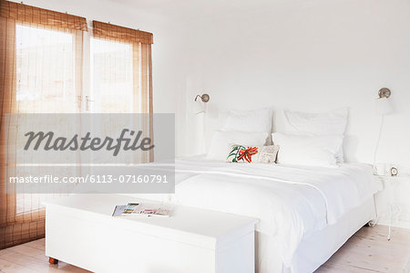 Bed and bench in white bedroom