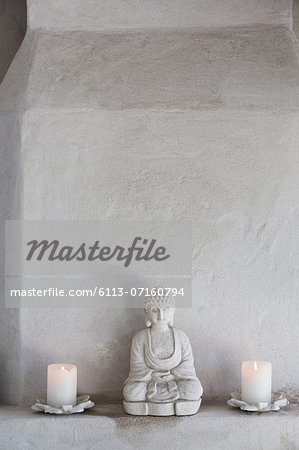Buddha figurine and candles on ledge