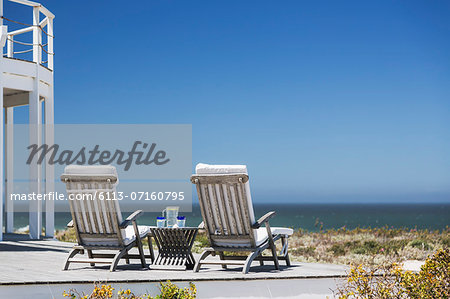 Lounge chairs on patio overlooking ocean