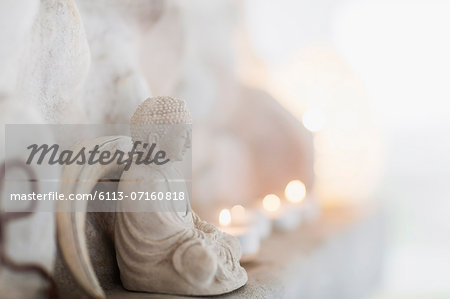Buddha figurine and candles on ledge Buddha figurine and candles on ledge