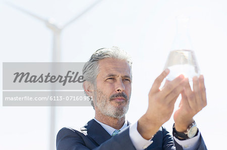 Businessman holding glass of water outdoors