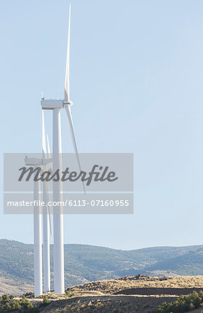 Wind turbines spinning in rural landscape