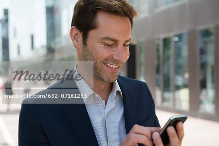 Businessman using smartphone outdoors