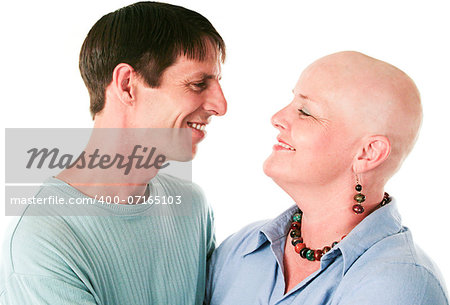 Cancer patient smiles at her loving, supportive husband.  White background.