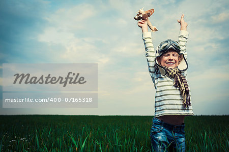 Boy with airplane in a field