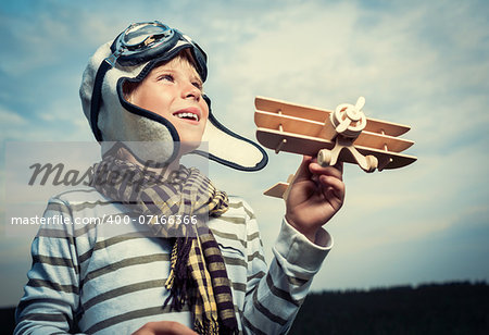 Smiling boy with wooden plane