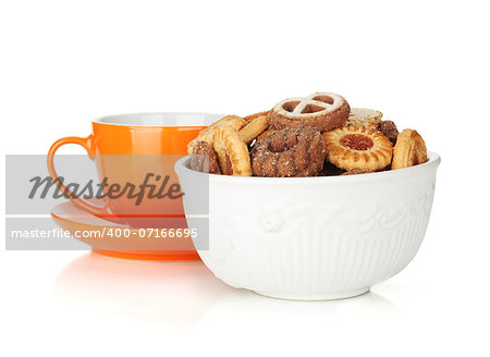 Various cookies in bowl and orange tea cup. Isolated on white background