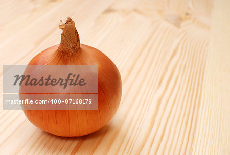 Whole white onion with skin, on a wooden table