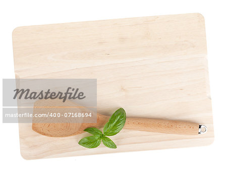 Cooking utensil and basil leaves over cutting board. Isolated on white background