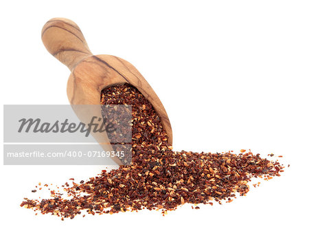 Rose hip herbal tea in an olive wood scoop over white background.