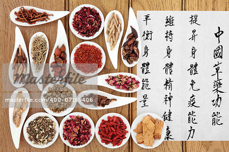 Traditional chinese herbal medicine with mandarin calligraphy on rice paper over oak background. Translation describes the medicinal functions to increase the bodys ability to maintain body and spirit health and balance energy.