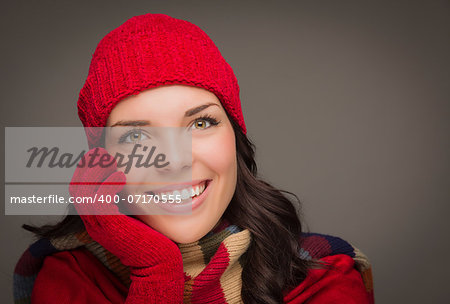 Happy Mixed Race Woman Wearing Winter Hat and Gloves on Gray Background.