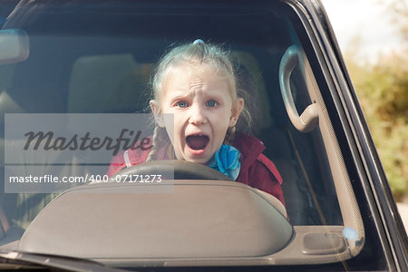 Crying scared girl driving the car