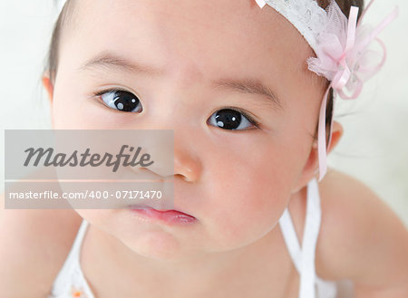 Close up face of Asian baby girl with curious look