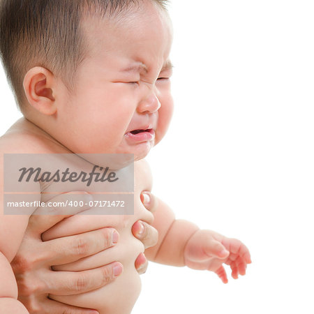 Sad Asian baby boy crying, sitting isolated on white background