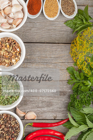 Colorful herbs and spices selection. Aromatic ingredients on wood table with copyspace