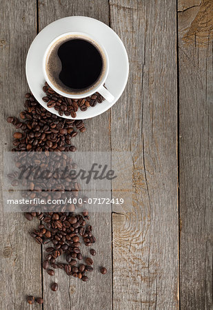 Coffee cup and beans on wooden table background with copy space