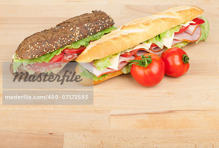 Fresh sandwiches with meat and vegetables and tomatoes on wood table