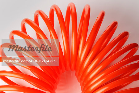 Orange red spiral plastic air hose used for pneumatic tools.