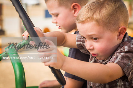 Adorable Young Boys Playing on an Old Tractor in a Rustic Outdoor Fall Setting.