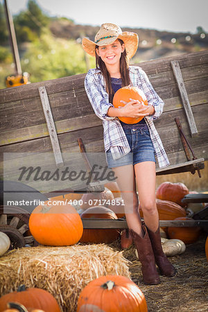 Preteen Girl Wearing Cowboy Hat Portrait at the Pumpkin Patch in a Rustic Setting.