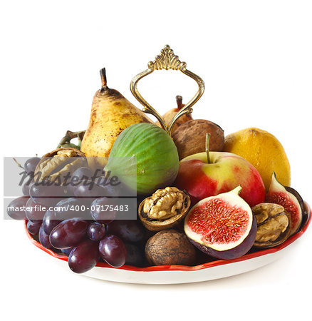 Delicious ripe fruits and nuts on a dessert plate.
