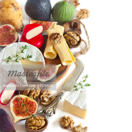 Assortment of delicious cheese and fruits on a white.