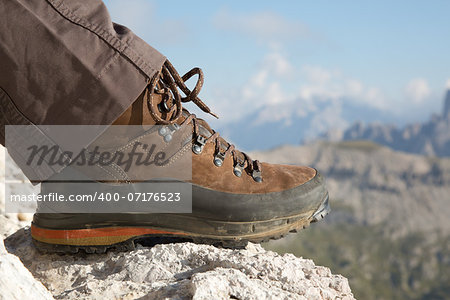 Hiking boots of a hiker on a rock in the mountains